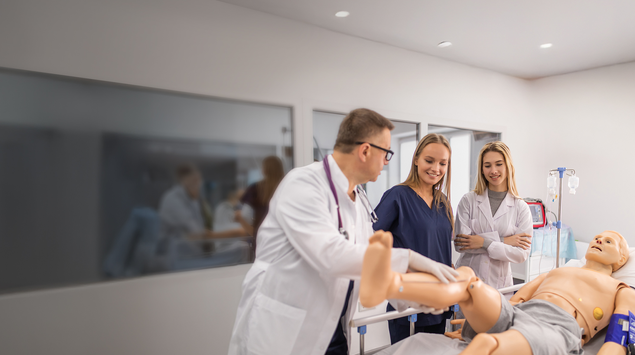 Doctor demonstrating a knee procedure on a mannequin to students as part of training and skill development